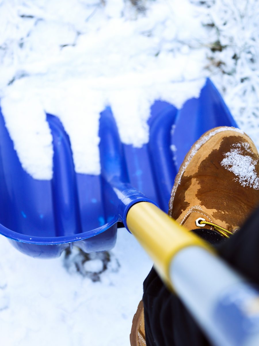 Man worker in uniform ,shoveling snow . close up image